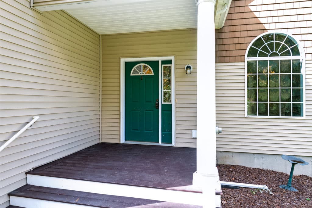 Covered front entry with the green front door