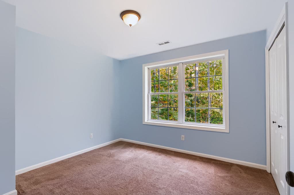 Bedroom with a window to the woods